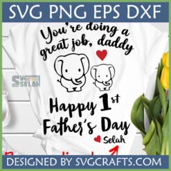 First Father's Day Elephant SVG design on a white t-shirt with a daddy elephant and baby elephant, red heart, and 'You're doing a great job, daddy Happy 1st Father's Day' text.