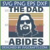 The Dad Abides SVG design featuring a silhouette of 'The Dude' from The Big Lebowski with sunglasses and beard, against a retro striped background, with text 'SVG PNG EPS DXF' and 'DESIGNED BY SVGRAFTS.COM'.